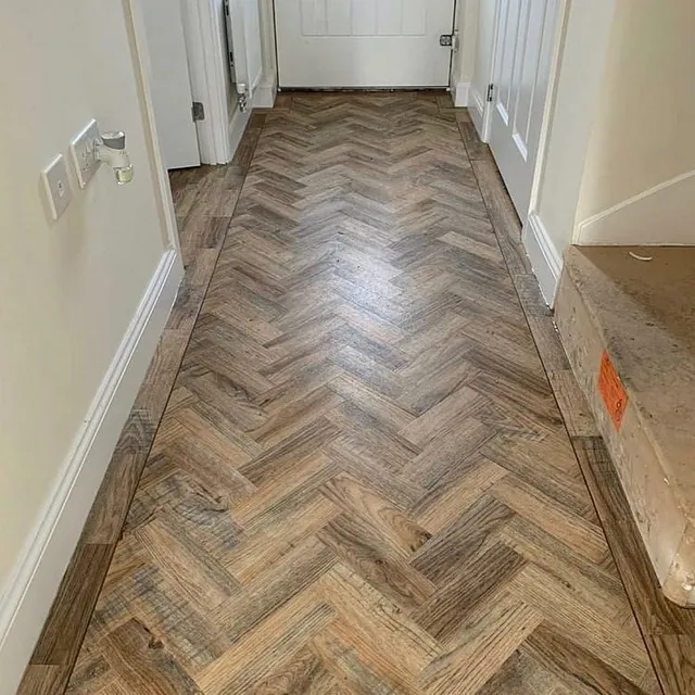 Polyflor Camaro fitted in Cambridge Oak parquet with a 3mm coffee coloured design strip border throughout